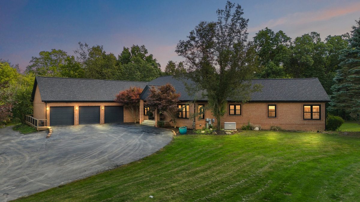 Clean residential exterior with driveway and evening lights.