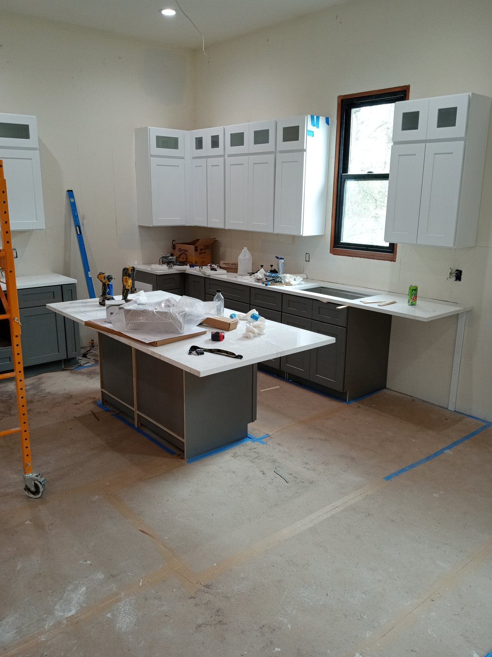 Kitchen refresh work with cabinetry and protected flooring.